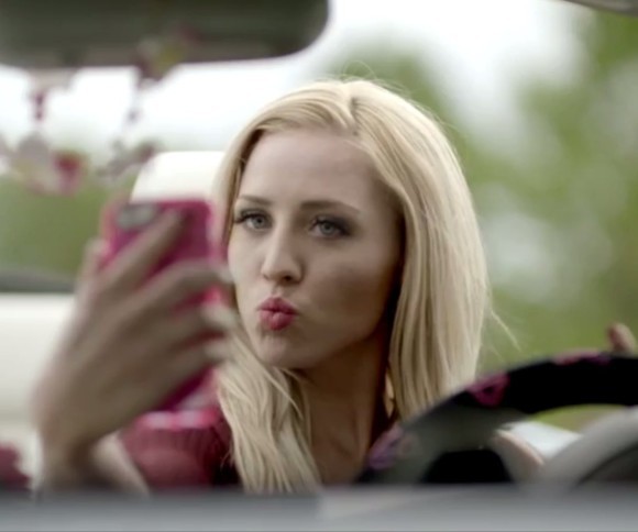 Blonde Frau macht Selfie im Auto 