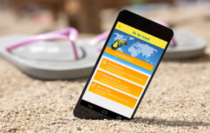 Smartphone mit Reise-App am Strand 