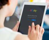 Frau surft mit Tablet auf eBay