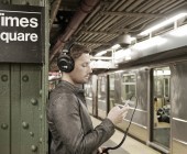 Mann steht mit Kopfhörer auf dem Kopf in einer Ubahnhaltestelle