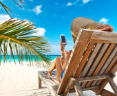 Smartphone-Nutzerin am Strand