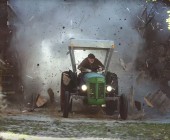 Mann fährt mit Traktor durch Scheunentor