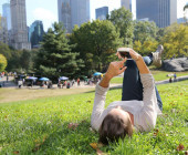 Liegender Smartphone-Nutzer im Park