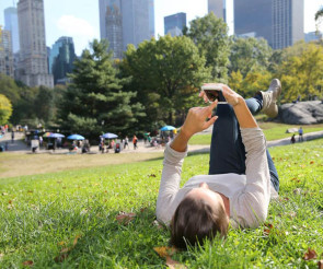 Liegender Smartphone-Nutzer im Park 