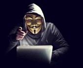Hacker mit Maske vor Notebook