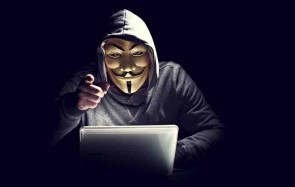 Hacker mit Maske vor Notebook 