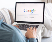 Laptop mit Google auf Sofa
