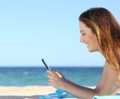 Frau mit Smartphone am Strand