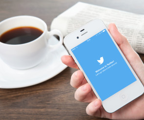 Twitter-App auf Smartpone neben Kaffetasse 