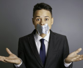 Businessman with silver tape over his mouth