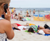 Frau telefoniert am Strand