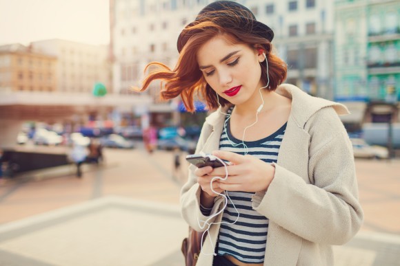 Frau mit Smartphone hört Musik 