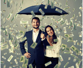 Paar unter Regenschirm im Geldregen